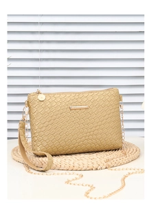 Close-up of beige woven plaid mini bag with gold chain strap and metal zipper detail