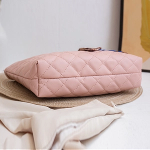 Pink quilted faux leather tote bag with elegant diamond stitching on a woven texture base