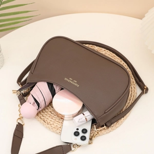 Brown lychee leather saddle bag with wide shoulder strap and spacious interior