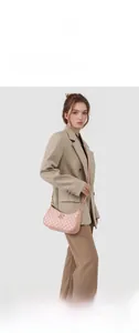 Detail of pink crescent bag featuring monogram M patterns and round metallic logo