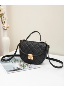Détail du sac à main matelassé noir avec fermoir doré et bandoulière tressée élégante