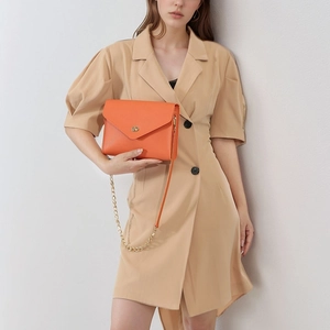 Vibrant orange pebble leather envelope crossbody bag with gold chain strap for women