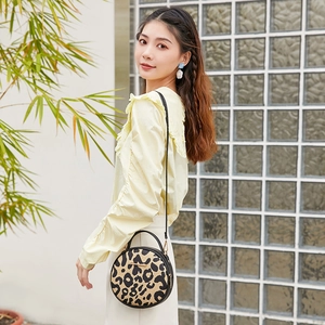 Chic vintage leopard print round crossbody bag with top handle and gold-tone hardware