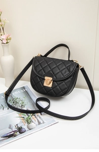 Détail d'un sac à main noir matelassé avec fermoir doré et motif de broderie chic
