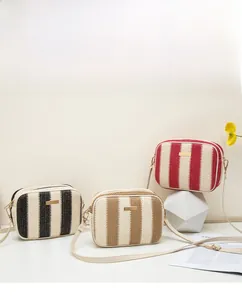 Detail of three striped straw camera bags in color-block designs with thin straps