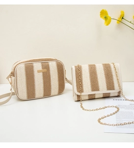 Detailed view of woven straw camera bag set with contrast stripes and gold hardware