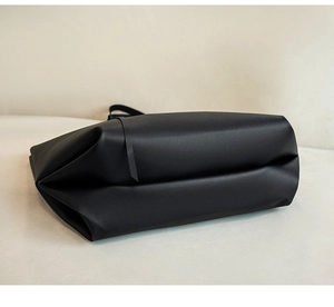 Gros plan d'un grand sac cabas noir montrant le cuir mat et la base large du sac