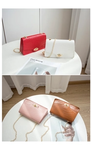 Detailansicht von vier Mini-Kettenhandtaschen mit Kroko-Prägung in Rot, Weiß, Rosa und Braun