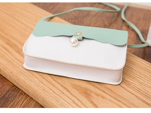 Détail du rabat vague vert menthe et fermoir perle sur le sac à bandoulière en similicuir