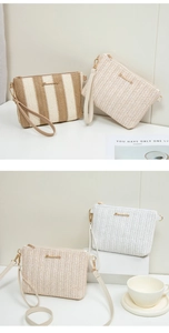 Detail of woven striped crossbody bag with gold zipper and adjustable shoulder strap