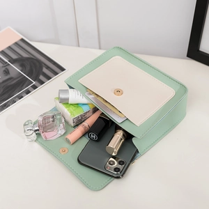 Sac bandoulière vert menthe et beige montrant l'espace intérieur pour essentiels