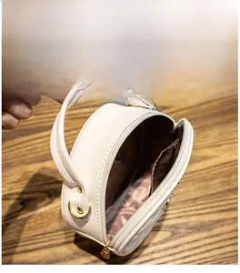 Détail du petit sac rond blanc montrant la doublure intérieure et le grand espace