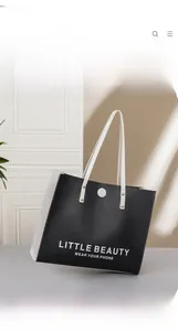 Detail of black and white tote bag with letter print and metal rivet decoration