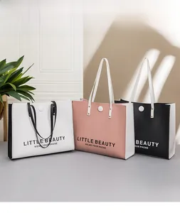 Three minimalist faux leather tote bags with letter prints and slender shoulder straps