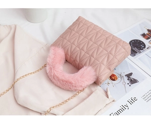 Detail of pink quilted square bag with faux fur handle and golden chain strap