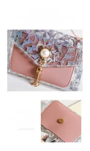 Détail d'un sac en cuir rose avec fermoir oreilles de chat en perles et glands dorés
