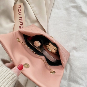 Quilted mini chain shoulder bag in pink showing interior storage capacity