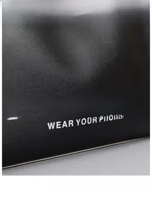 Macro shot of black textured leather tote with white Little Beauty artistic typography
