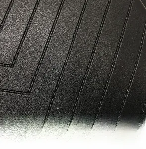 Gros plan sur la texture du cuir noir grainé avec des coutures parallèles détaillées