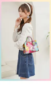 Colorful watercolor gradient handbag with golden chain strap worn by a female model