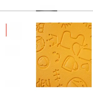 Detail of yellow stone-grain faux leather with embossed crown and heart patterns