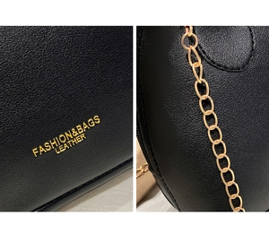 Detail of black leather shell bag featuring gold logo and metallic chain strap