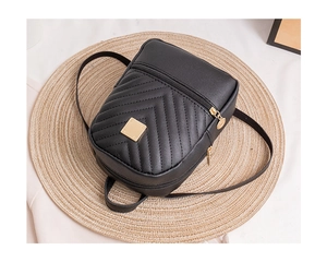 Close-up of black chevron quilted small backpack with gold metal hardware and zipper