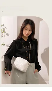 Close-up of white quilted crossbody bag with gold chain strap and elegant faux leather texture
