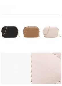 Detailed view of geometric quilted stitching and gold chain on leather crossbody square bag