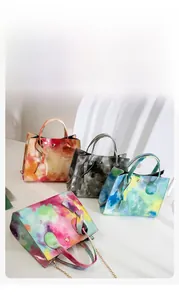 Detail of colorful tie-dye mini crossbody bags with glossy texture and metal chains