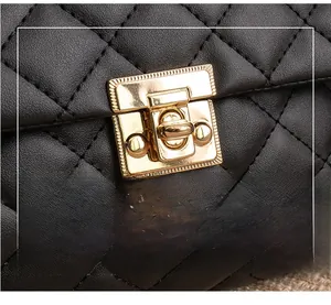 Détail d'un sac à main en cuir noir matelassé avec fermoir rotatif en métal doré