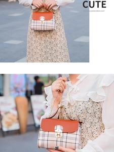 Detail of plaid tote bag featuring orange pebble leather flap and gold chain strap