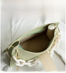 Detail view of the light green faux croc hobo bag with white chain and inner zipper pocket