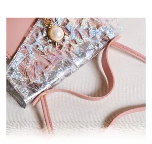 Détail de la bandoulière en cuir rose et du motif géométrique sur le mini sac clair