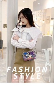 Chic rainbow snake pattern crossbody bag with gold chain strap on a fashion model