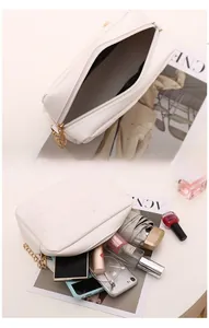 Detailed interior of a white quilted crossbody bag with golden chain and spacious storage