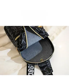 Detail view of the spacious inner compartment and gold zipper of the black crossbody bag