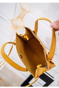 Top view of yellow leather handbag showing internal compartment and magnetic closure