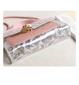 Détail du mini sac à main holographique rose avec motif laser et pompon doré sur l'anneau