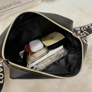 Sac bandoulière noir avec sangle LOVE montrant l'espace intérieur pour vos essentiels