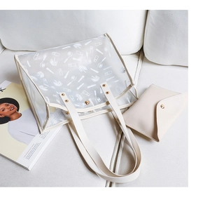 Detailed view of clear PVC tote with white print and matching cream interior pouch