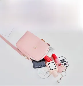 Flat lay of pink woven mini crossbody bag showing internal compartments and storage capacity