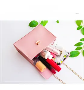Pink small square bag interior with golden cross lock and gold chain strap detail