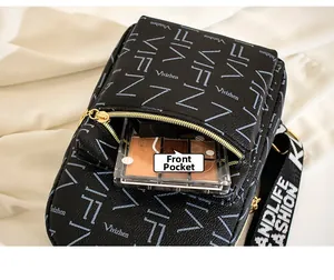 Macro view of front zipper pocket on black monogram crossbody bag for small items