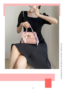Detail of pink faux leather handbag with floral silk scarf handle and gold twist lock