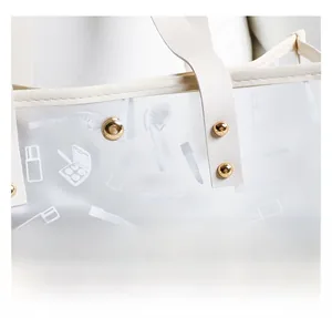 Detail of precise stitching and gold rivets on the white leather tote bag handle