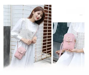 Detailed view of pink mini woven phone bag featuring pearl charms and gold cat-ear clasp
