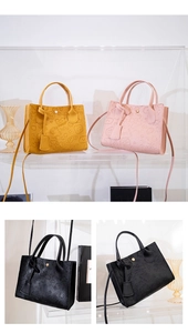 Detailed view of embossed cartoon patterns on yellow, pink and black tote bags