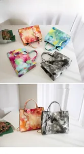 Detailed display of four tie-dye gradient handbags in multiple colors and textures