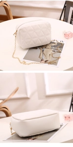 Detail of white quilted crossbody bag with golden chain strap and triangle embroidery
